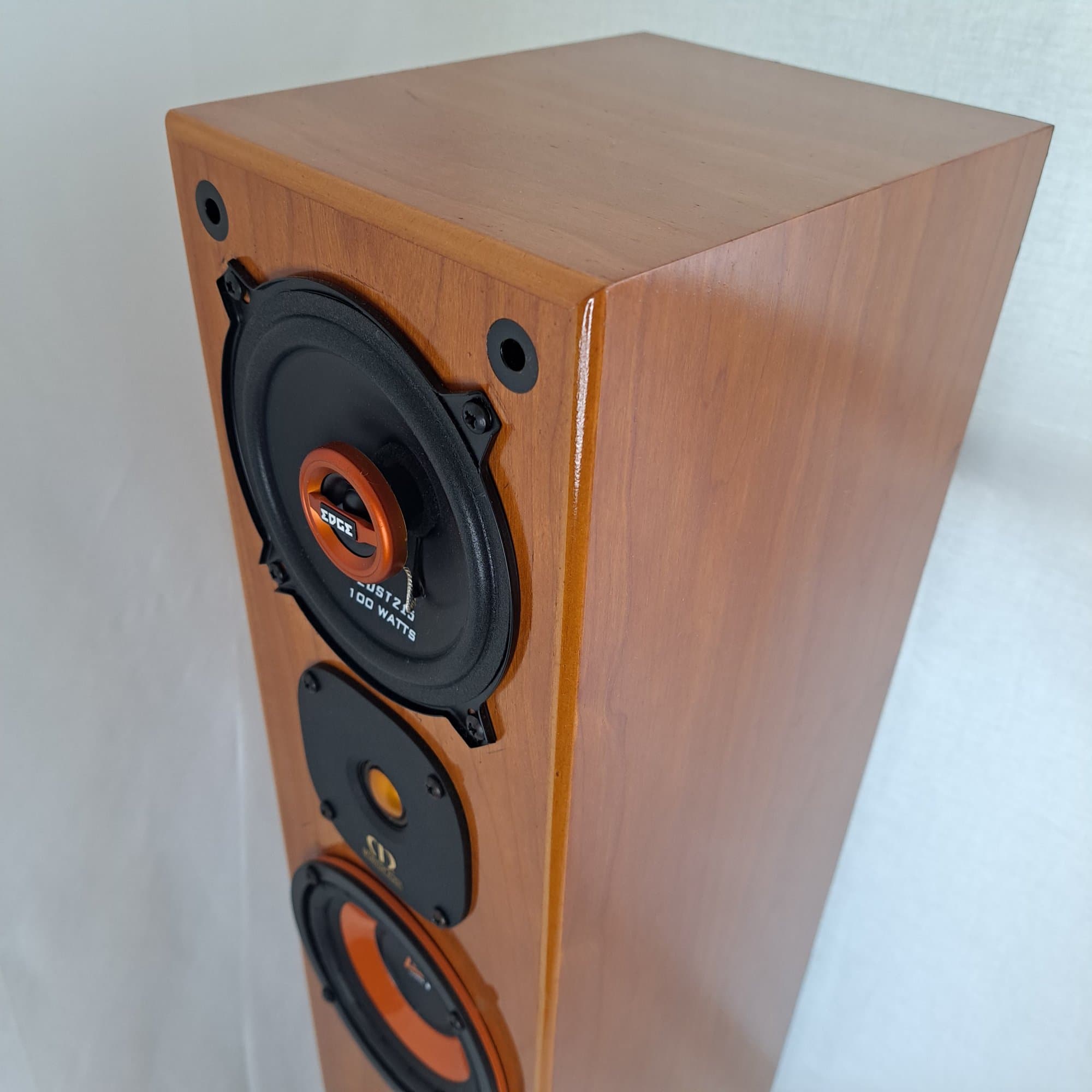 Tall cherry wood speaker cabinet with an orange lit base